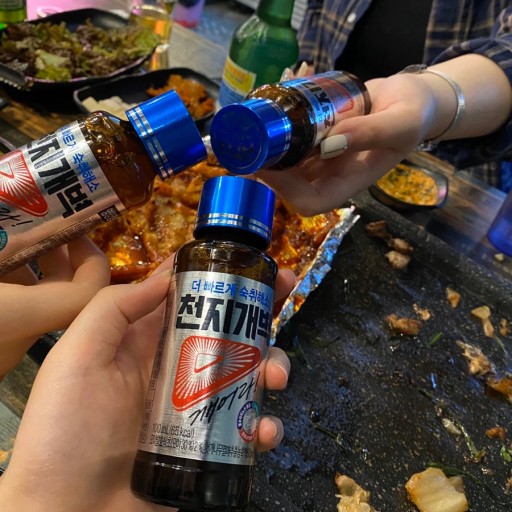 CJGB anti-hangover bottles in hand at a restaurant